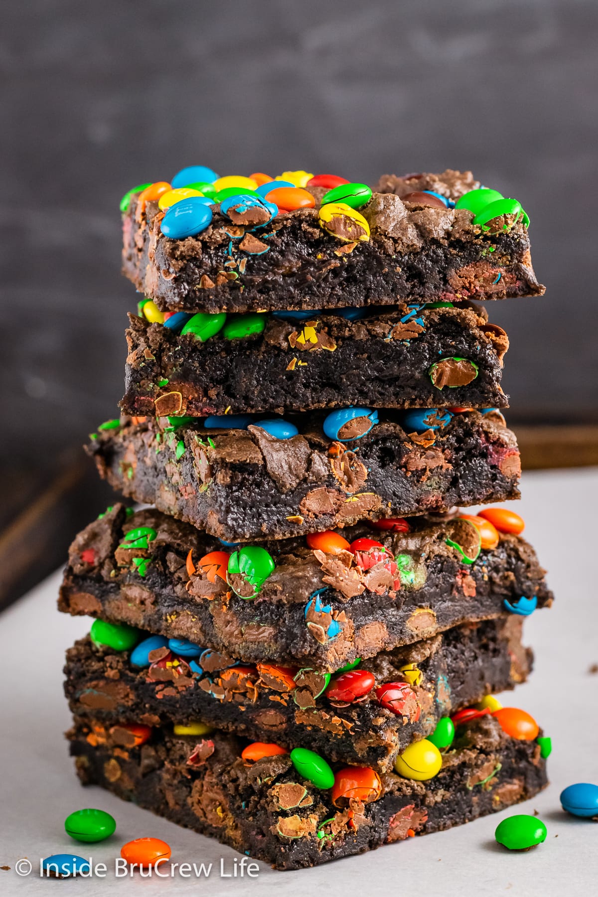 A stack of 6 brownies with colorful candies inside and on top.