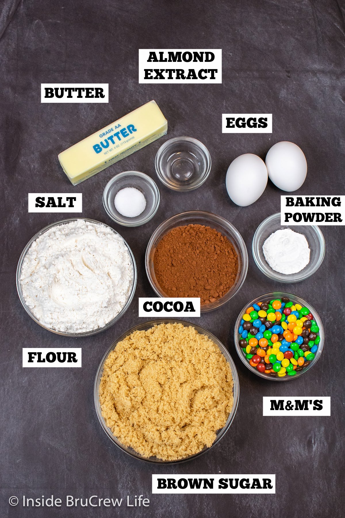 A black board with bowls of ingredients needed to make homemade chocolate brownies.