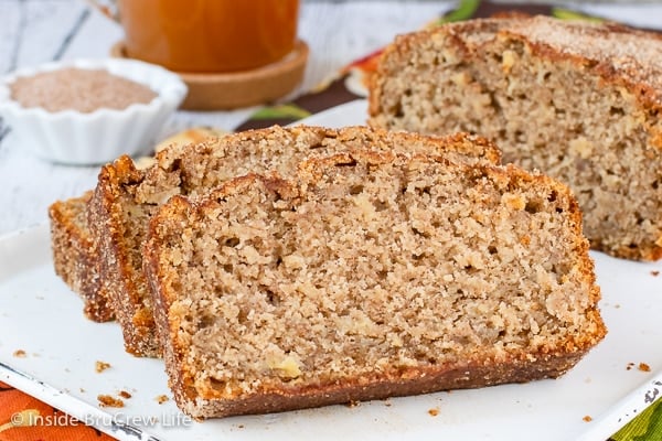 Slices of apple cider bread lying on a white tray.