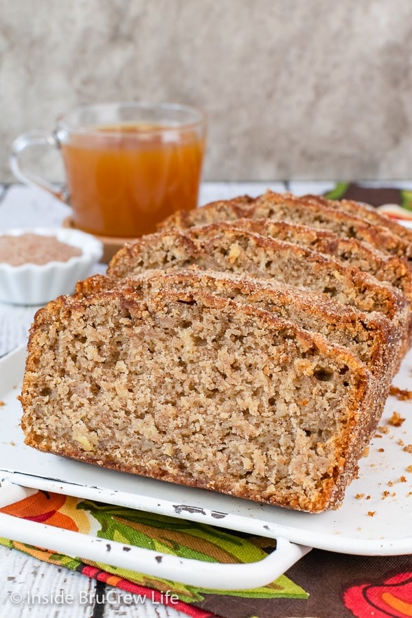 A white tray with slices of apple cider bread on it.