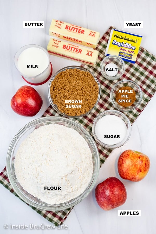 Overhead picture of a white board with bowls of ingredients to make easy apple cinnamon rolls.