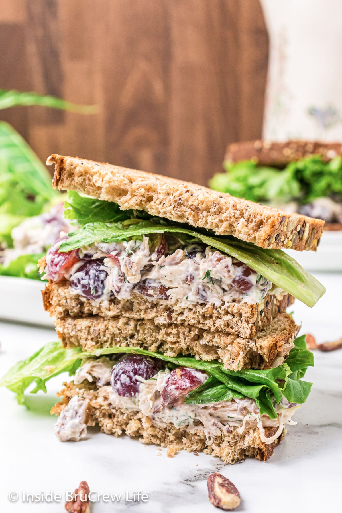 Two sandwich halves filled with chicken salad and stacked on top of each other.