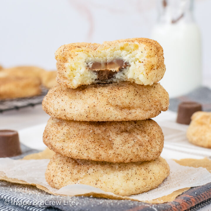 A stack of cinnamon sugar cookies stuffed with Rolo candies on a towel.