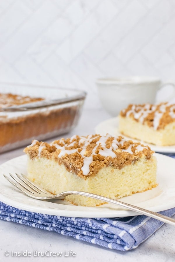 Two white plates with pieces of easy coffee cake drizzled with a sweet glaze.