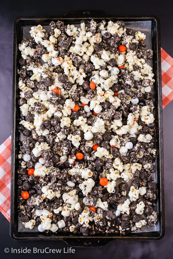 Overhead picture of a sheet pan filled with cookies and cream popcorn and holiday candies.