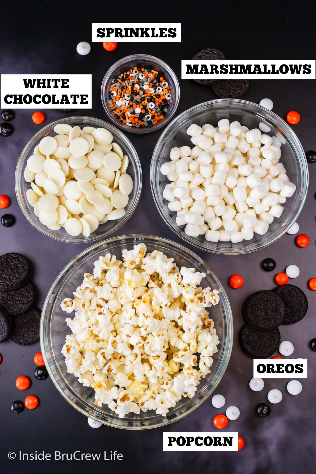 Bowl of ingredients needed to make chocolate covered popcorn with sprinkles.