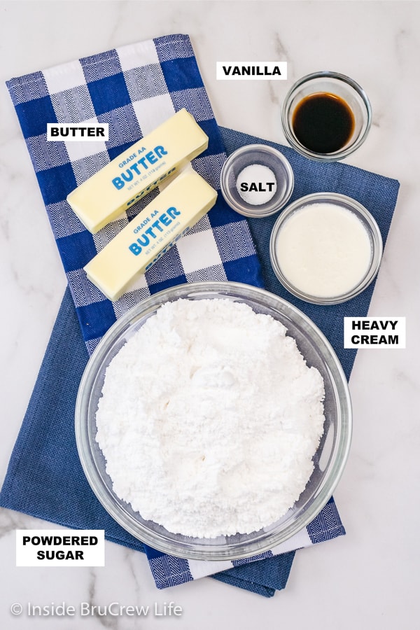 Overhead picture of a white board with bowls of ingredients needed to make vanilla buttercream frosting.