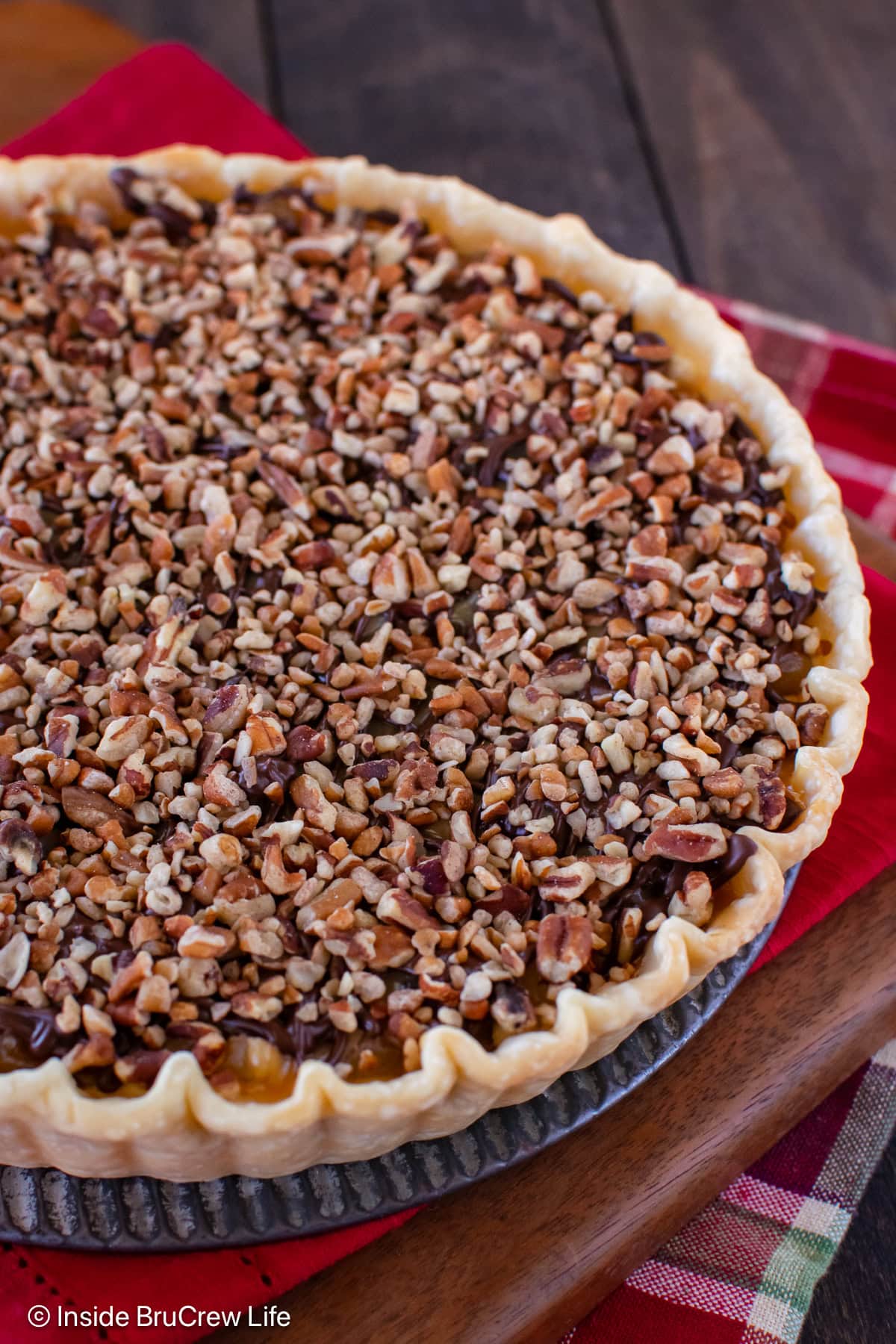 An apple tart topped with caramel and pecans.