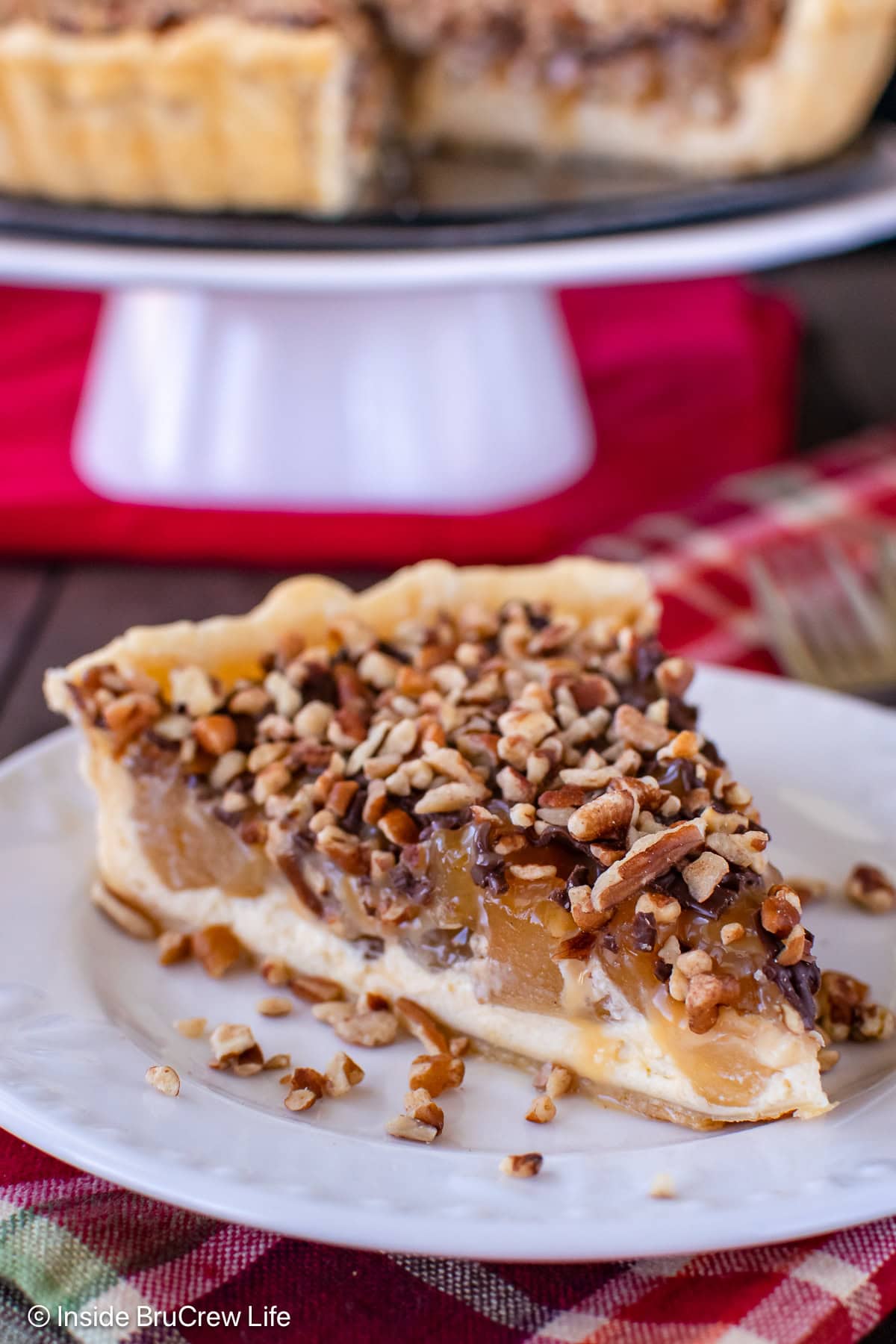 A slice of caramel apple cheesecake tart on a white plate.