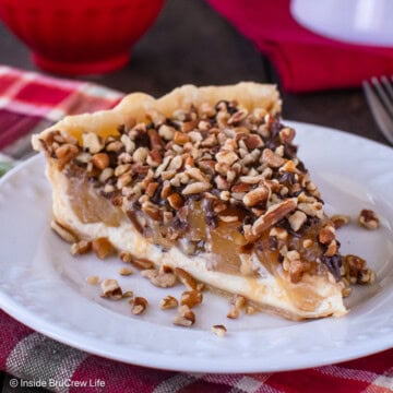 A slice of cream cheese apple tart topped with pecans and caramel.