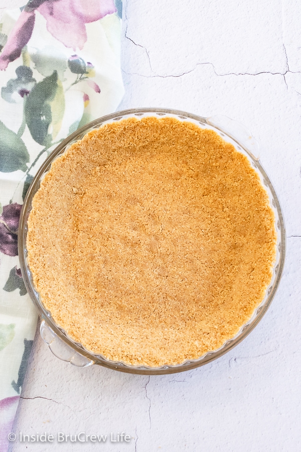 Overhead picture of a graham cracker pie crust in a glass pie pan.