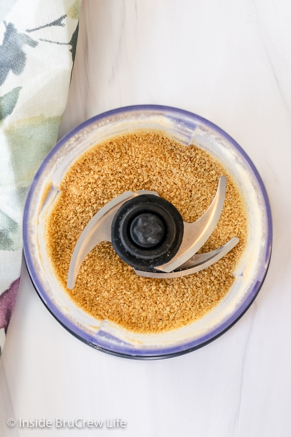 Overhead picture of food processor filled with graham cracker crumbs.