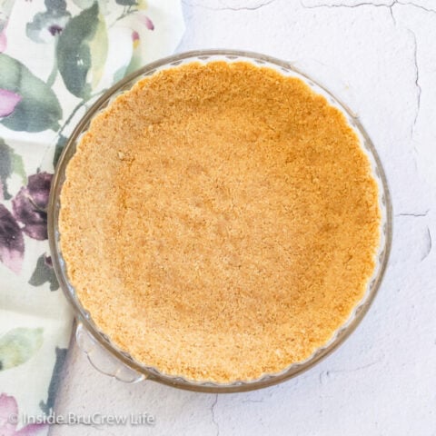 Overhead picture of a graham cracker pie crust in a glass pie plate.