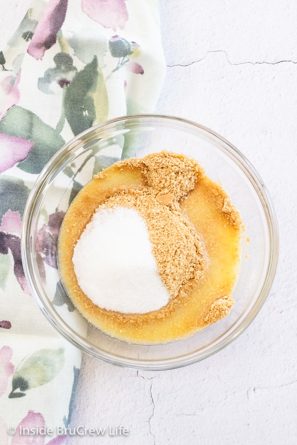 Overhead picture of a glass bowl filled with graham crumbs, sugar, and melted butter.