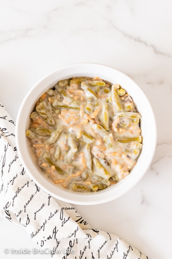 A white dish on a white board filled with French's green bean casserole.