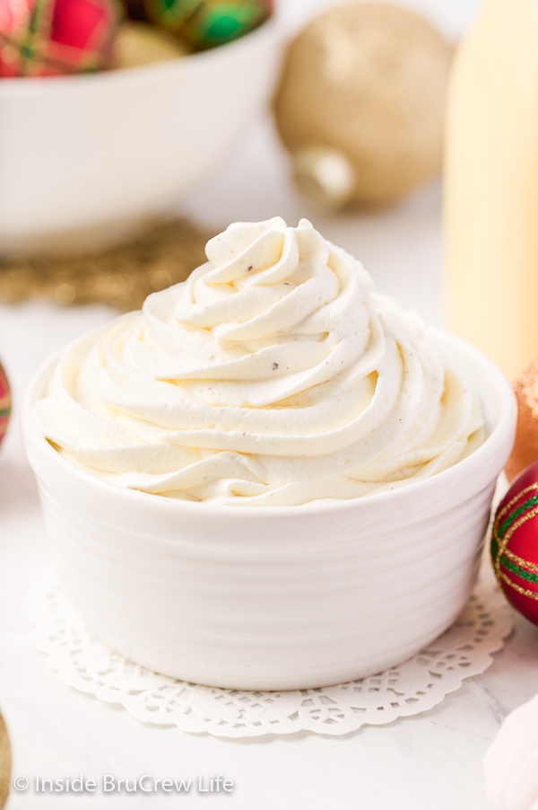 A white bowl with a swirl of homemade whipped cream made with eggnog in it.