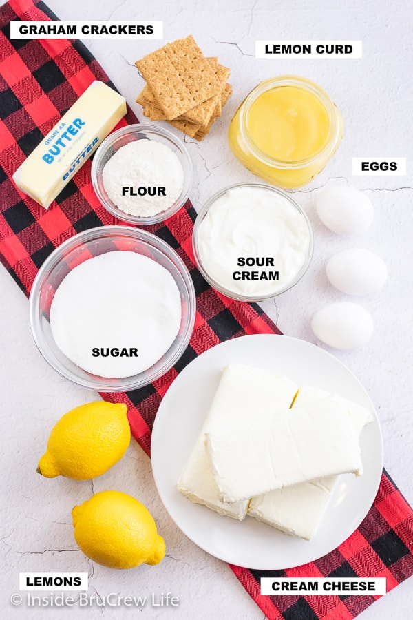 An overhead picture of a white board with bowls of ingredients needed to make a pan of lemon cheesecake bars.