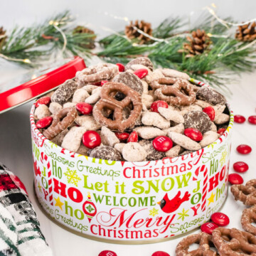 A christmas tine filled with reindeer chow snack mix.