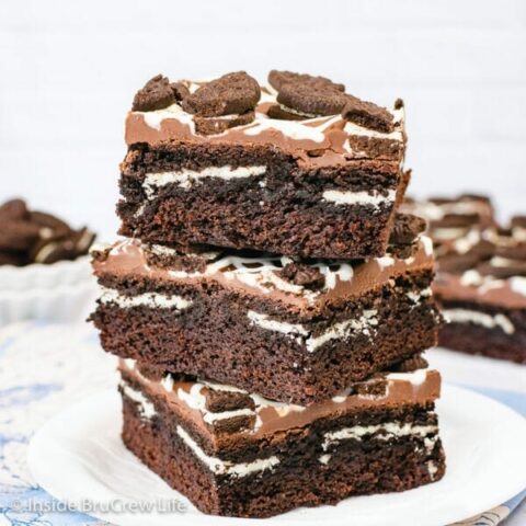 A white plate with three oreo stuffed brownies stacked on it.