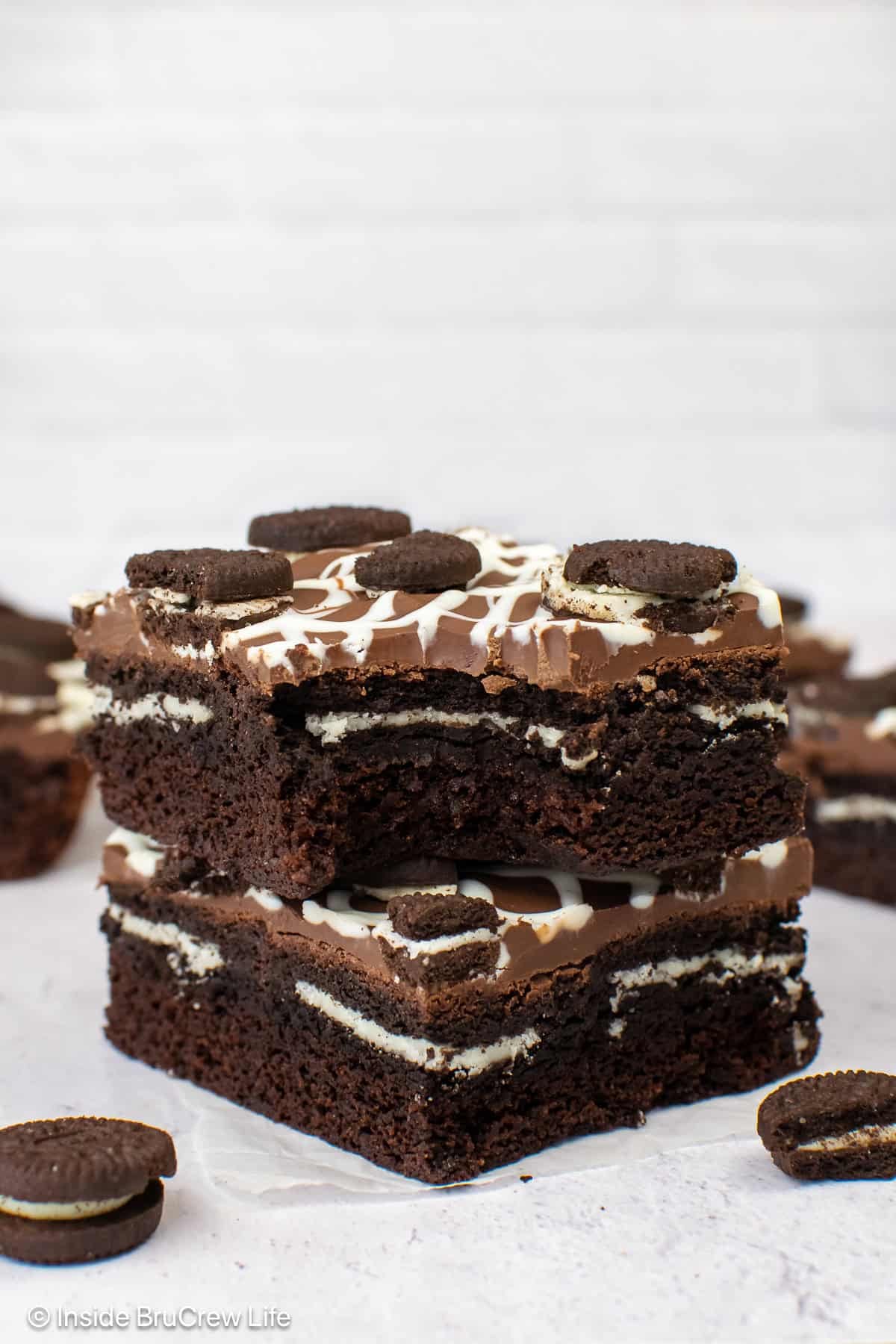 Two stuffed Oreo brownies with a bite out of the top one.