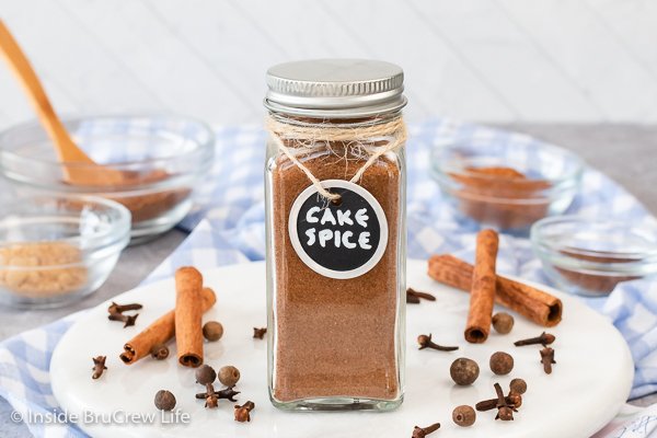 A glass jar with a metal lid filled with cake spice.