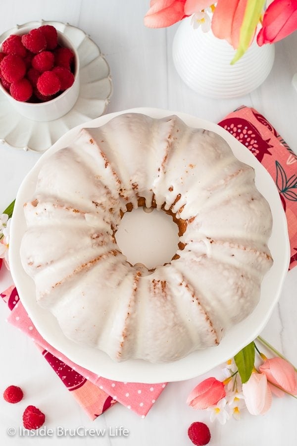 Overhead picture of a bundt cake covered in glaze on a cake plate.