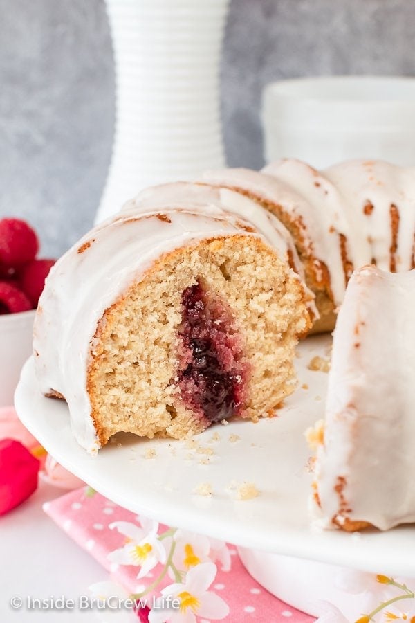 A bundt cake with a jelly center on a white cake plate.