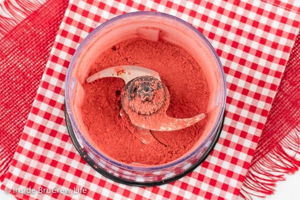 A food processor with ground strawberry powder in it.