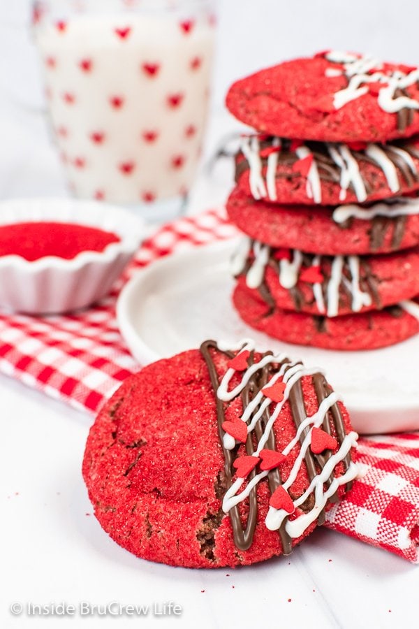 A red sugar cookie leaning against a stack of cookies.