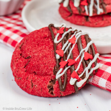 A red strawberry cookie drizzled with chocolate and sprinkles.