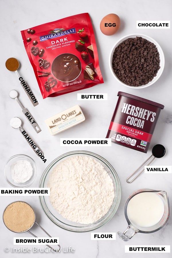 Bowls of ingredients to make chocolate scones on a white board.