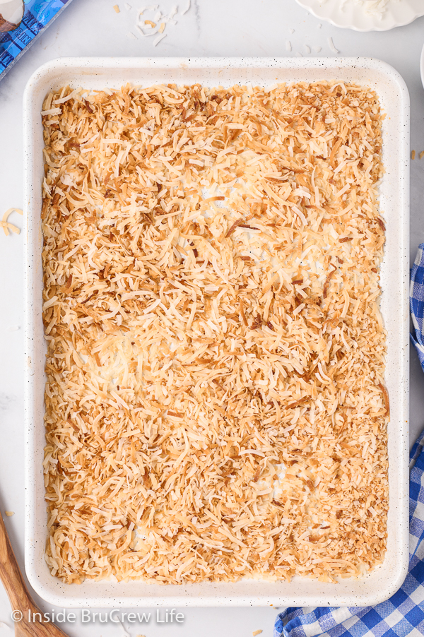 A sheet pan with toasted coconut on it.