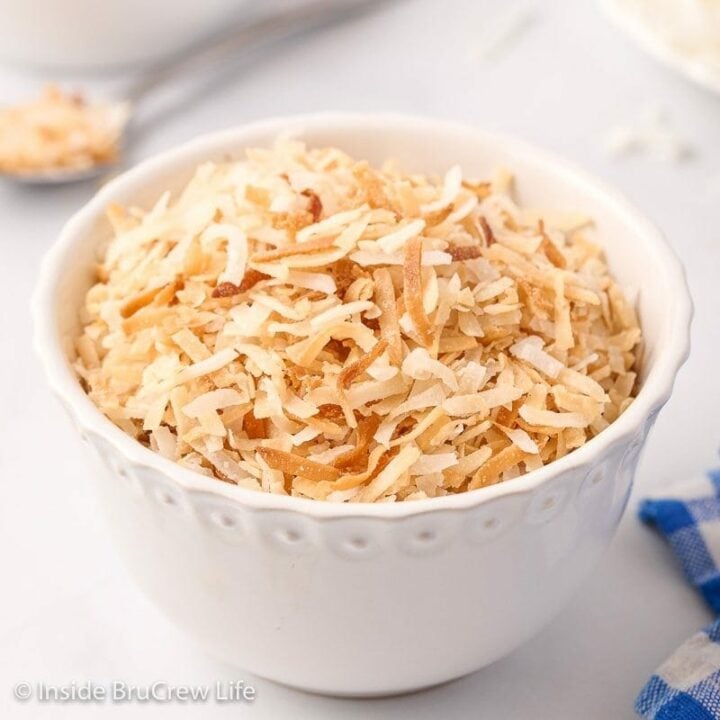 A white bowl filled with toasted coconut.