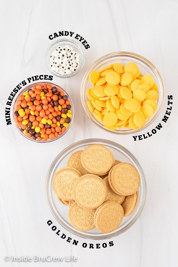 A white board with bowls of ingredients to make chocolate covered Oreos.