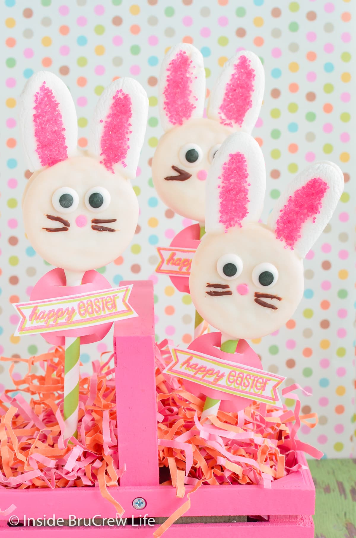 Three Oreo bunnies stuck into a pink basket.