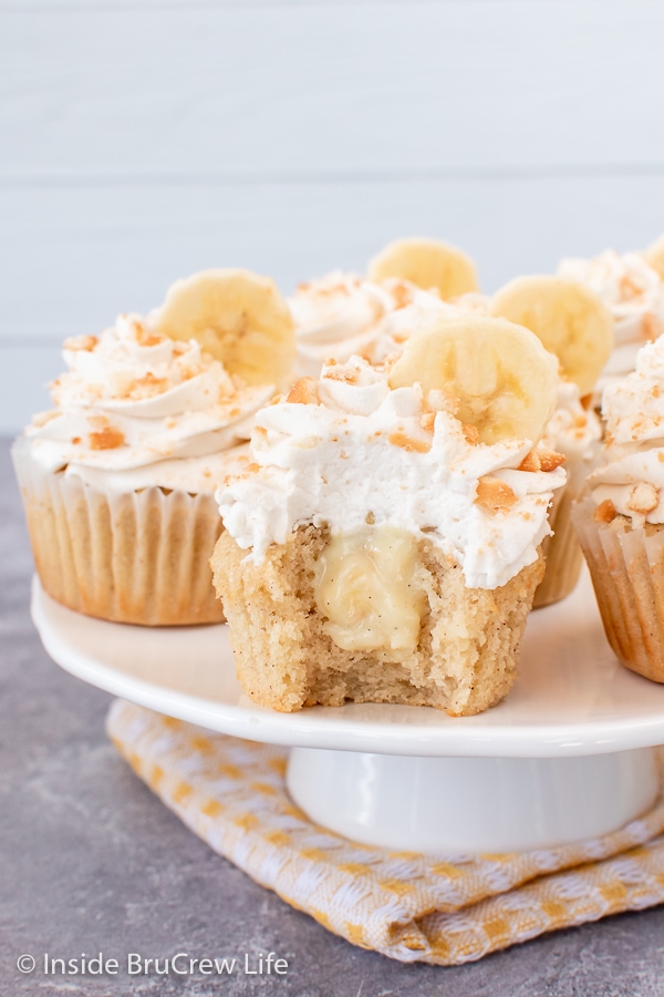 A white cake plate with frosted cupcakes on it.