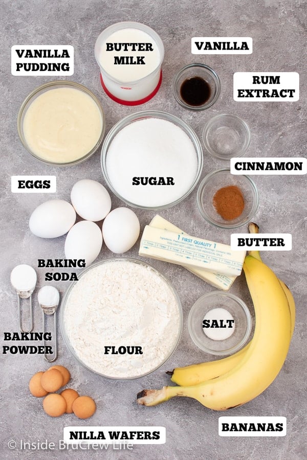 A gray board with bowls of ingredients needed to make pudding filled cupcakes.