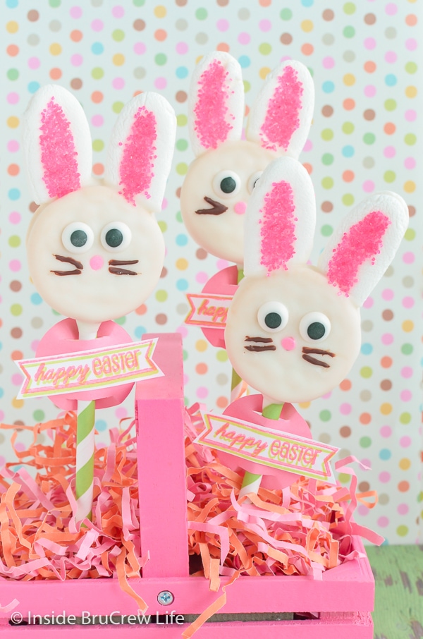 Three bunnies made from Oreo cookies and chocolate melts on straws.