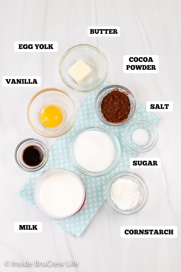 A white board with bowls of ingredients needed to make homemade pudding.