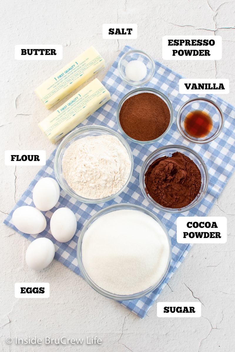 Bowls of ingredients needed to make espresso brownies on a white board.