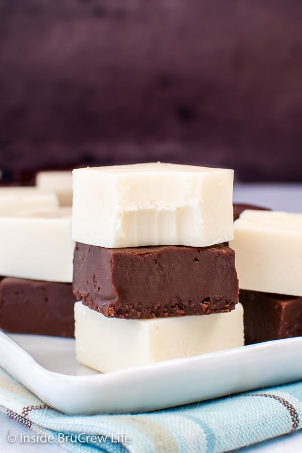 Squares of chocolate and vanilla frosting fudge stacked on top of each other.