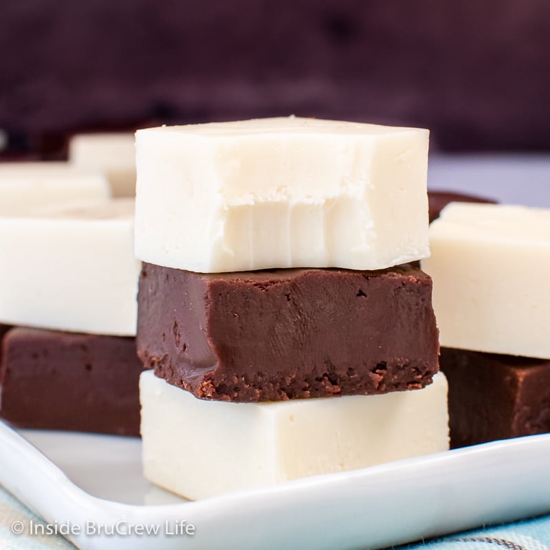 A white plate with squares of fudge stacked on it.