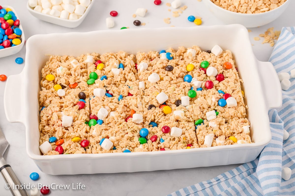 A white baking dish with M&M rice krispie treats in it.