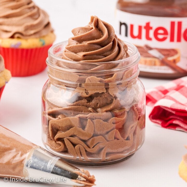 A clear jar filled with a swirl of chocolate hazelnut frosting.