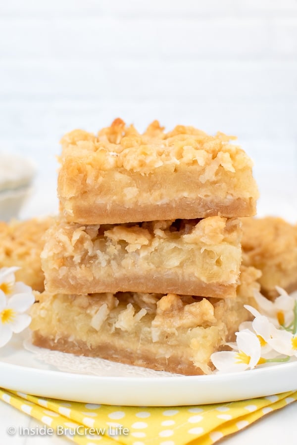 A stack of three pineapple bars on a white plate.