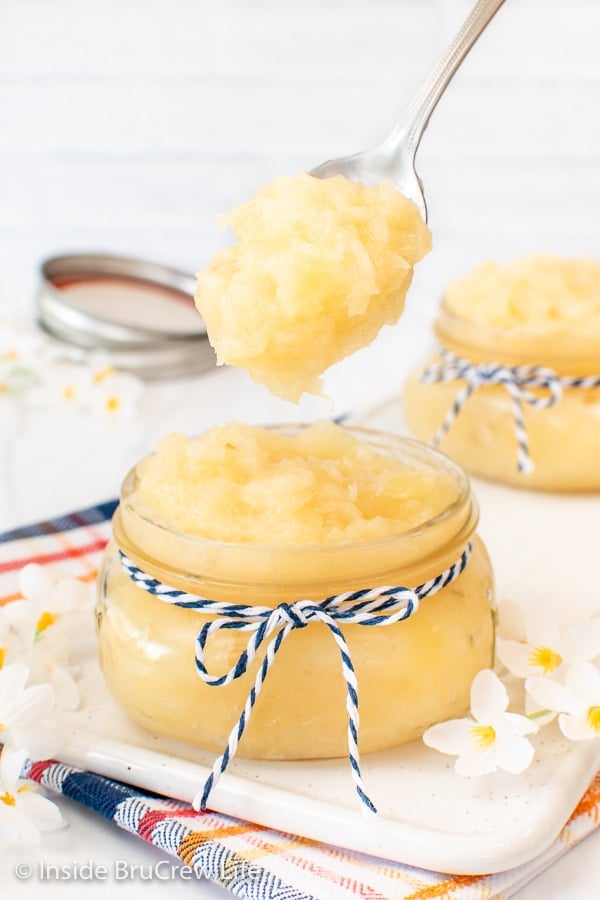 A jar of pineapple pie filling with a spoon lifting some out.