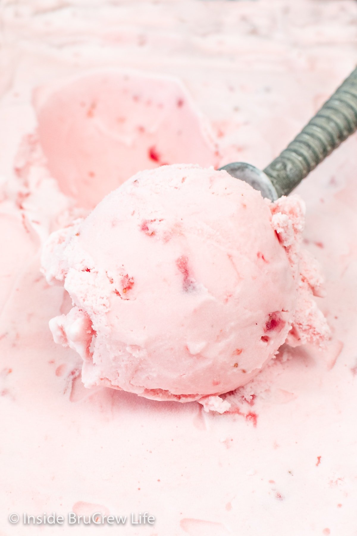 A scoop of pink strawberry ice cream.