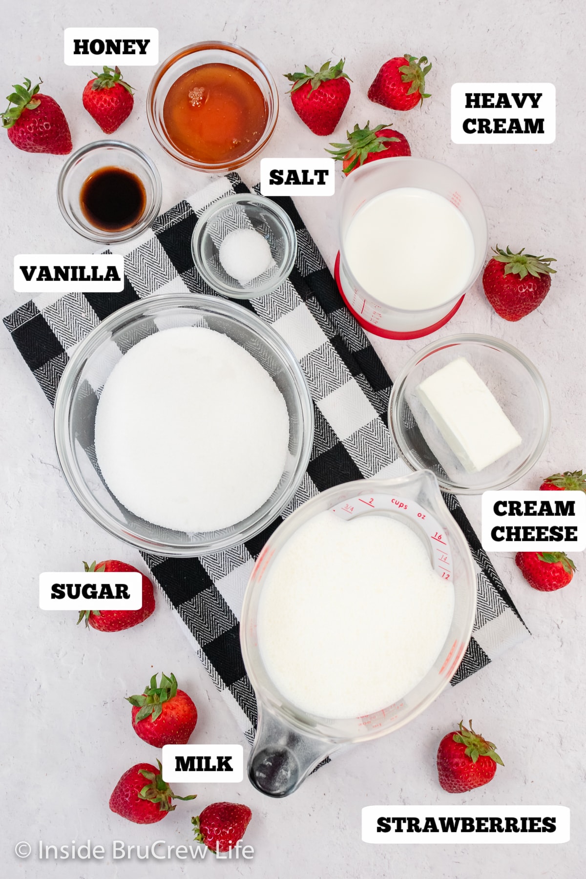 Bowls of ingredients needed to make a homemade ice cream with strawberries.