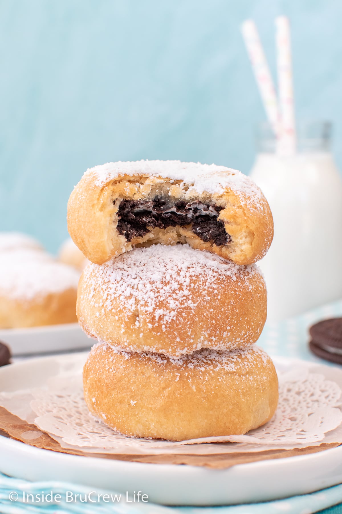 Three biscuits filled with Oreos stacked on a plate.