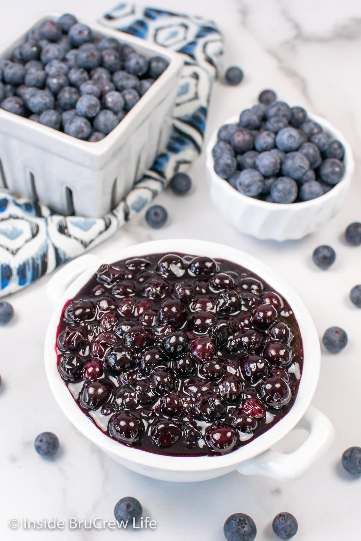Overhead picture of white bowls filled with blueberries and pie filling.